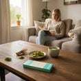 Load image into Gallery viewer, Young woman sitting on the couch eating a Wayne Raven Matcha White Chocolate bar