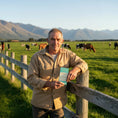 Load image into Gallery viewer, A happy dairy farmer customer holding his favourite New Zealand milk chocolate bar in the alpines