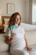 Load image into Gallery viewer, Woman eating Wayne Raven chocolate gifts in the hotel room while visiting in New Zealand