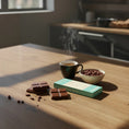 Load image into Gallery viewer, broken pieces of a dark milk chocolate bar placed next to Wayne Raven packaging
