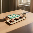 Load image into Gallery viewer, close up of Wayne Raven Milk Chocolate Gift box, broken pieces of chocolate on a platter
