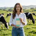 Load image into Gallery viewer, A woman dairy farmer happily holding her favorite milk chocolate bar from Wayne Raven
